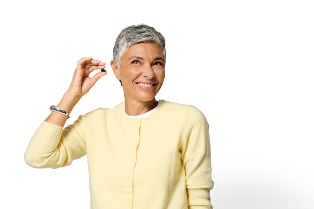 Philips HearLink NXT poziționat în ureche, demonstrat de o utilizatoare